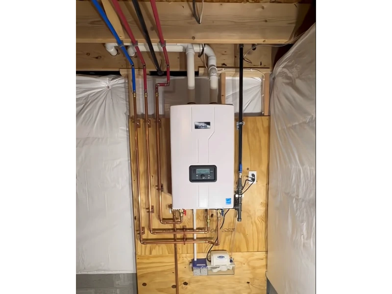 Wall-mounted tankless water heater with copper supply lines, gas line, PVC venting and condensate pump